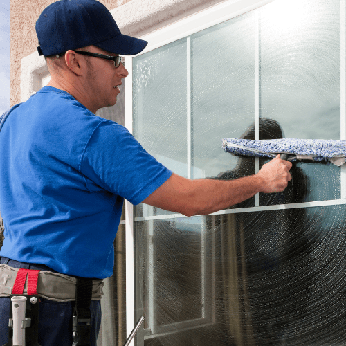 a man cleaning a big window. 