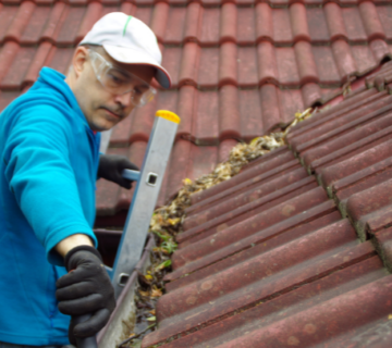 a man cleaning a gutter