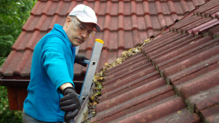 a man cleaning a gutter
